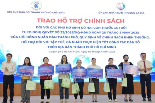 TS.BS Huỳnh Minh Chín, Phó giám đốc Sở Y tế TP.HCM (ngoài cùng bên phải) trao quà và tiền thưởng cho 7 phụ nữ tiêu biểu sinh con thứ 2 trước 35 tuổi. Ảnh: Nguyễn Thuận.