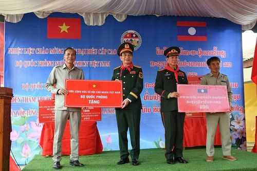 Đại tướng Phan Văn Giang và Đại tướng Khamliang Outhakaysone trao quà tặng cho đại diện Trường tiểu học Thongnammoun.