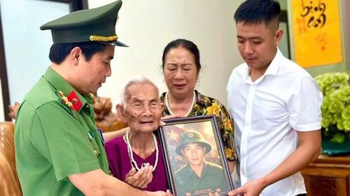 Thành viên đoàn công tác trao ảnh phục dựng cho vợ, con liệt sĩ Lê Sỹ Hoan.
