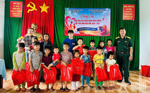  Đại tá Lê Văn Hùng, Phó đoàn trưởng, Đoàn Kinh tế - Quốc phòng 726 cùng nhà hảo tâm trao quà tặng các em học sinh. 