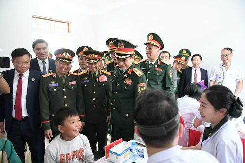 Đại tướng Phan Văn Giang và Đại tướng Khamliang Outhakaysone tham quan khu vực khám, cấp thuốc miễn phí cho nhân dân biên giới. Ảnh: Trần Nam.