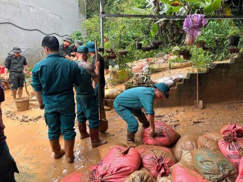 Cán bộ, chiến sĩ dân quân tự vệ phối hợp với Công an và lực lượng tại chỗ hỗ trợ người dân di chuyển đất đá, dọn dẹp nhà cửa sau mưa lớn.