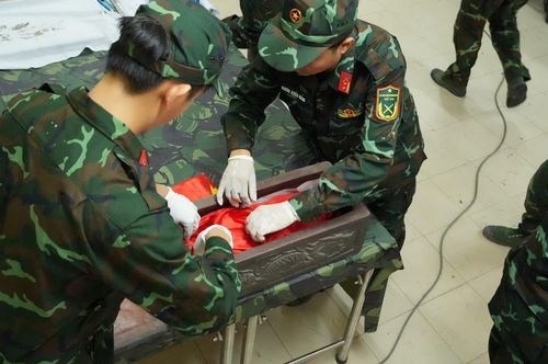 Những bộ hài cốt tìm thấy được cẩn trọng đưa vào quách sành một cách trang nghiêm