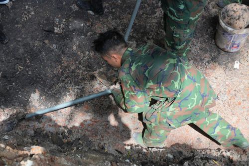 Động tác đào ngang lớp đất bên trên để tránh ảnh hưởng đến hài cốt, nếu có