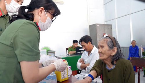 Cụ Bùi Thị Lan được cán bộ Công an hỗ trợ lấy mẫu sinh phẩm ADN