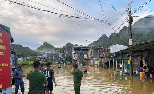 Cán bộ, chiến sĩ Công an xã, lực lượng ANTT cơ sở Mường Khương xuyên đêm hỗ trợ người dân thôn Na Đẩy di dời tài sản ra khỏi khu vực ngập lụt.
