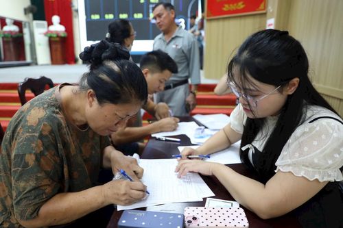 Người dân làm thủ tục nhận bàn giao hồ sơ thửa đất tái định cư. Ảnh: NS