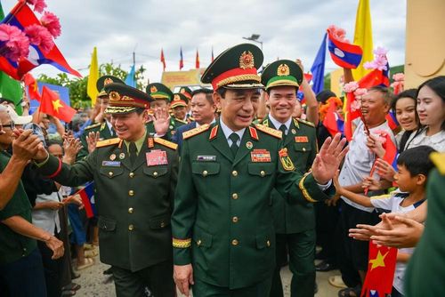 Bà con nhân dân biên giới chào mừng hai Phó Thủ tướng, Bộ trưởng Quốc phòng Việt Nam-Lào đến dự lễ sơ kết kết nghĩa cụm dân cư hai bên biên giới.