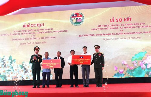 Hai đồng chí Phó Thủ tướng Chính phủ, Bộ trưởng Bộ Quốc phòng hai nước Việt Nam - Lào tặng quà cho đại diện ban quản lý thôn Thủy Phong và Xốp Tờng. Ảnh: Viết Lam
