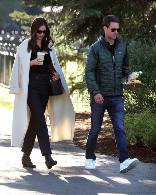 Người mẫu Miranda Kerr xuất hiện cùng chồng là tỷ phú Evan Spiegel. Miranda Kerr diện trang phục mang tinh thần quiet luxury, khoác hờ trench coat bên ngoài áo hai dây đen ôm sát, kết hợp quần jeans tối màu ống suông cạp cao. Doanh nhân Spiegel lại diện trang phục thể thao đơn giản.