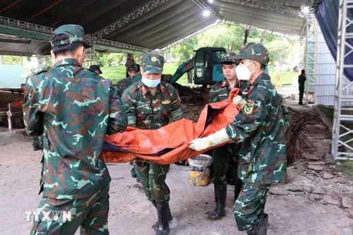 Lực lượng tìm kiếm, quy tập hài cốt liệt sỹ của Bộ Tư lệnh Thành phố Hồ Chí Minh cẩn trọng đưa hài cốt các anh hùng liệt sỹ khỏi hố đào về nơi thực hiện các quy trình tiếp theo.(Ảnh: Xuân Khu/TTXVN)