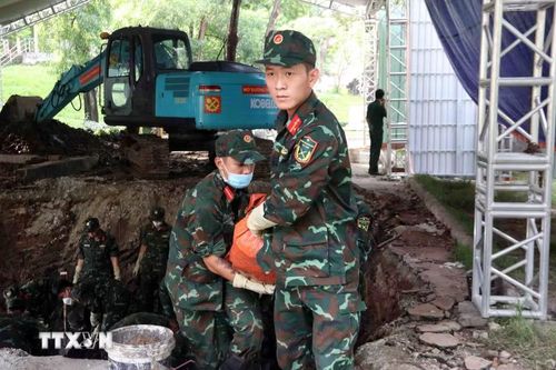 Lực lượng tìm kiếm, quy tập hài cốt liệt sỹ của Bộ Tư lệnh Thành phố Hồ Chí Minh cẩn trọng đưa hài cốt các anh hùng liệt sỹ khỏi hố đào về nơi thực hiện các quy trình tiếp theo. (Ảnh: Xuân Khu/TTXVN)