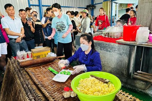 Sau khi tham quan chợ nổi, nhiều du khách tiếp tục hành trình đến các làng nghề truyền thống, vườn cây ăn trái, cơ sở làm hủ tiếu hay các khu du lịch sinh thái ven sông. Ảnh: Du khách chờ mua bánh tráng ở lò hủ tiếu trên sông. 