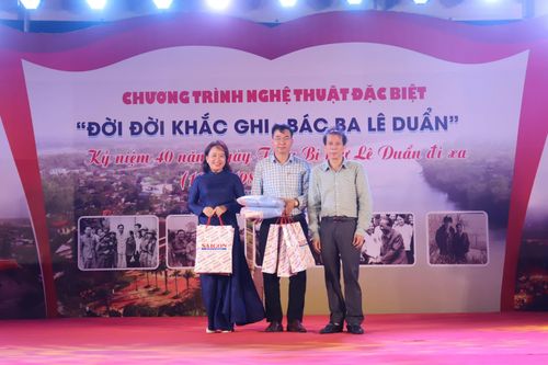Đại diện Báo Sài Gòn Giải Phóng trao quà cho đại diện lãnh đạo xã Triệu Phong - Ảnh: T.P