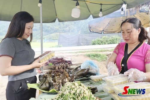 Du khách tìm hiểu về các món ăn địa phương tại chợ phiên bản Vặt Hồng, phường Mộc Châu.