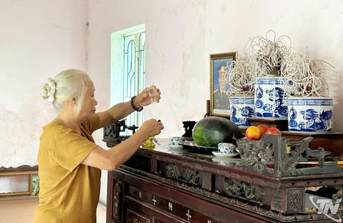 Bà Nguyễn Thị Minh thắp hương cho chồng trong căn nhà mới.