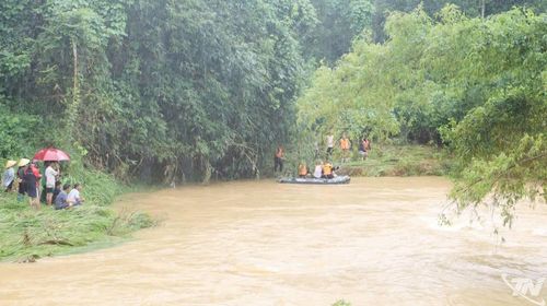 Lực lượng chức năng tìm kiếm cháu bé trong điều kiện thời tiết mưa liên tục và nước lũ diễn biến phức tạp.