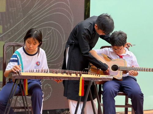 Học sinh trải nghiệm đàn tranh và guitar phím lõm trong chương trình tại Trường THCS Trần Văn Ơn. Ảnh: Fanpage Ban đờn ca Đó Đây.