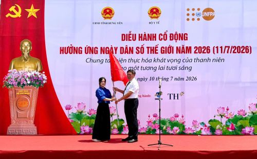 Lãnh đạo Bộ Y tế thực hiện nghi thức trao cờ phát động đoàn diễu hành hưởng ứng Ngày Dân số Thế giới năm 2026. Ảnh: Hải Yến