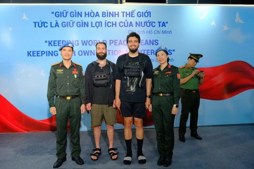Các sĩ quan GGHB Bộ Công an chụp ảnh lưu niệm với du khách quốc tế.