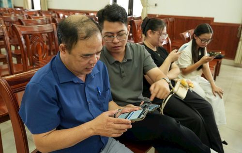 Cán bộ dự hội nghị được hướng thực hiện thao tác nhập dữ liệu trên thiết bị là điện thoại thông minh. Ảnh: Phương Lộc