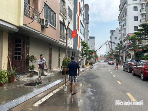 Người dân ngõ 343 An Dương Vương chung tay dọn dẹp vệ sinh, giữ gìn cảnh quan đô thị sau khi tuyến đường được mở rộng. Ảnh: Tuệ Lâm