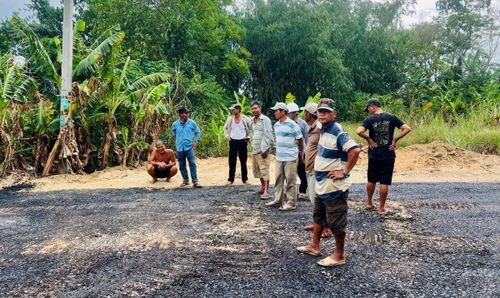 Người dân thôn Lệ Bắc vui mừng đi xem thi công thảm nhựa.