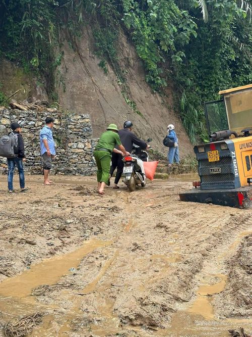  Lực lượng chức năng tỉnh Lai Châu hỗ trợ người dân qua các điểm đường bị mưa lũ ảnh hưởng. Ảnh: CÔNG AN TỈNH LAI CHÂU 