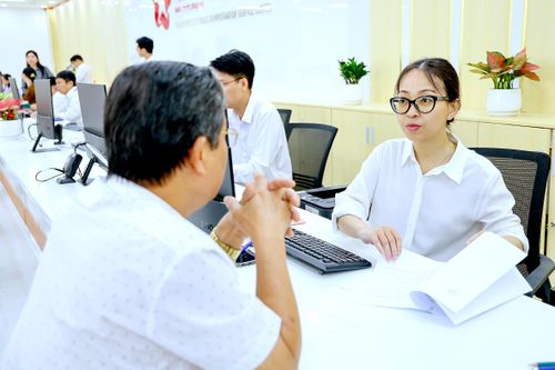  Công chức Trung tâm phục vụ hành chính công TPHCM (đặt tại phường Thủ Đức) đang giải quyết thủ tục hành chính cho người dân. ẢNH: LÊ THOA 