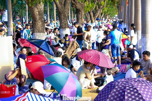 Hàng ngàn người trải chiếu, bạt, che ô, đem theo thức ăn nước uống ngồi bên bờ sông dưới trời nắng gắt hàng tiếng đồng hồ.