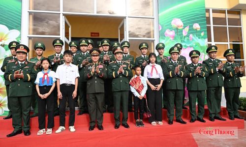 Phó Thủ tướng, Bộ trưởng Bộ Quốc phòng hai nước Việt Nam - Lào thăm hỏi, động viên các cháu là con nuôi Đồn Biên phòng Cửa khẩu Thanh Thủy. Ảnh: Nguyên Khánh