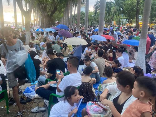 Người dân trật tự chọn vị trí ngồi xem đêm chung kết pháo hoa tại bờ đông sông Hàn, khu vực vỉa hè đường Trần Hưng Đạo. Ảnh: HỮU PHÚC