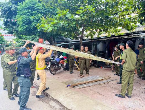 Lực lượng tham gia bảo vệ ANTT ở cơ sở xã Na Sang hỗ trợ công an chấn chỉnh các hành vi lấn chiếm hành lang, vỉa hè.