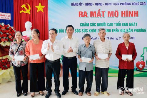 Đồng chí Lê Trường Sơn, Ủy viên Ban Thường vụ Thành ủy, Phó Chủ tịch UBND thành phố và Chủ tịch UBND phường Đồng Xoài Dương Hoài Pha tặng quà người cao tuổi tiêu biểu trên địa bàn phường. Ảnh: Quang Minh