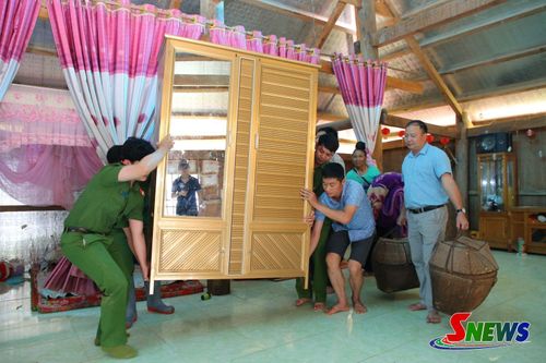 Lực lượng Công an xã Mường Giôn hỗ trợ người dân di chuyển đồ đạc đến nơi an toàn.