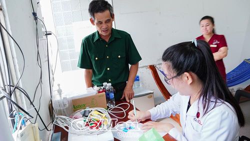 Bác sĩ Phòng khám Đa khoa Hòa Minh trả kết quả đo điện tim, khám sàng lọc cho người dân.