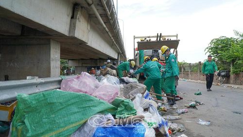 Công nhân vệ sinh môi trường bốc dỡ, thu gom lượng rác thải tồn đọng lâu ngày gây ô nhiễm.