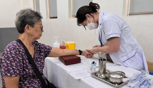 Đội ngũ y, bác sĩ thực hiện lấy mẫu xét nghiệm cho người dân tham gia chương trình khám sức khỏe. Ảnh: Võ Giang