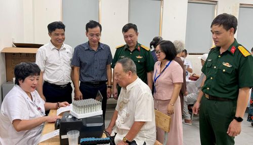 Lãnh đạo phường Ô Chợ Dừa và đại diện các đơn vị theo dõi, động viên đội ngũ y, bác sĩ và người dân. Ảnh: Võ Giang
