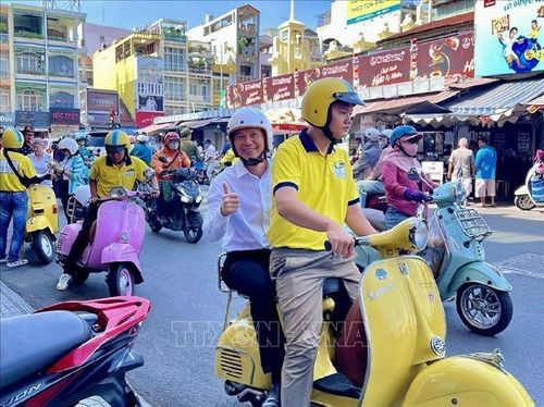 Du khách hào hứng trải nghiệm du lịch Thành phố Hồ Chí Minh bằng xe Vespa. Ảnh: Mỹ Phương/TTXVN