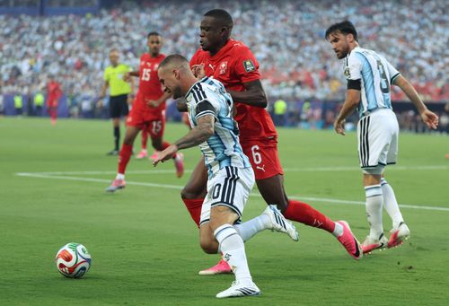 Tiền vệ Argentina Alexis Mac Allister (số 20) tranh bóng với tiền vệ Thụy Sĩ Denis Zakaria (số 6). Ảnh: AFP/TTXVN (Ảnh không cho phép bên thứ 3 khai thác, chia sẻ lại)