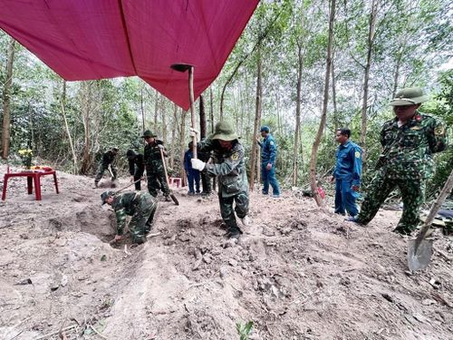 Các thành viên Đội K51 Đắk Lắk và các lực lượng cẩn thận đào từng lớp đất để tìm kiếm, quy tập hài cốt liệt sĩ trong Chiến dịch 500 ngày đêm. Ảnh: TTXVN phát
