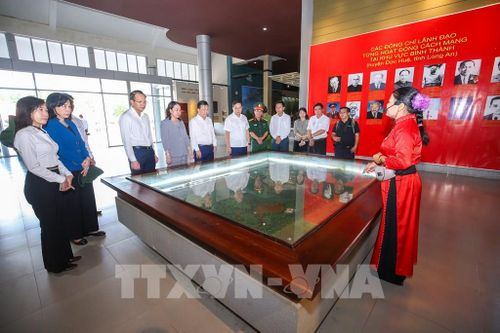 Tham quan Khu di tích lịch sử cách mạng Bình Thành, du khách lắng nghe những câu chuyện được kể qua các kỷ vật, tư liệu, thêm hiểu và trân trọng giá trị của hòa bình hôm nay. Ảnh: Giang Phương - TTXVN