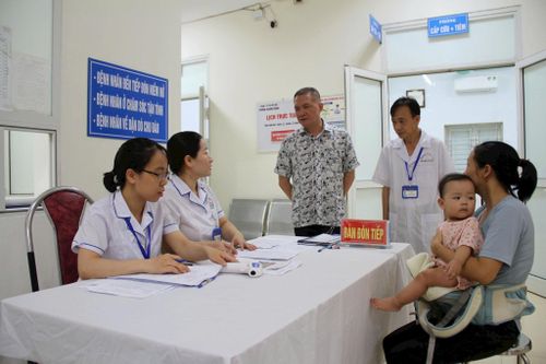 Chủ tịch UBND xã Mỹ Đức Nguyễn Quang Đường thăm hỏi, động viên các y, bác sĩ và người dân tham gia khám sức khỏe tại Trạm Y tế xã Mỹ Đức. Ảnh: Biên Phạm