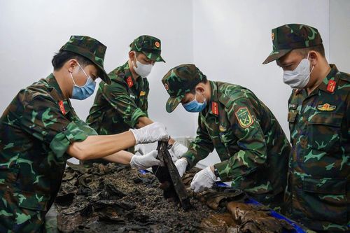 Lực lượng tìm kiếm hiện trường bóc tách từng lớp đất để quy tập hài cốt ở công viên Lê Thị Riêng. Ảnh: Hoài Bảo.