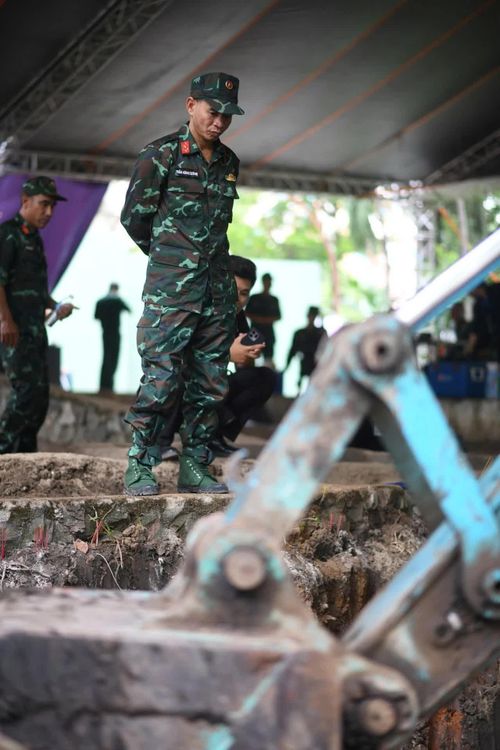 Thượng tá Cường quan sát kỹ lớp đất vừa được khai quật ở công viên Lê Thị Riêng. Ảnh: Duy Hiệu.