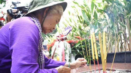 Bà Nguyễn Thị Lệ thắp hương tưởng niệm các Anh hùng liệt sĩ tại công viên Lê Thị Riêng. Ảnh: THANH CHIÊU