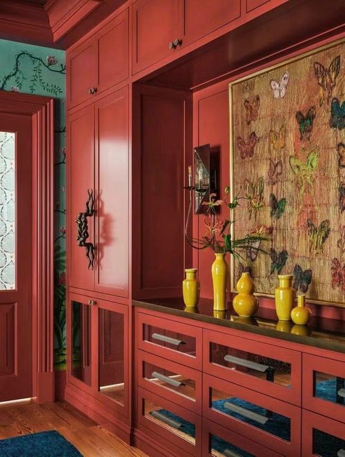 Tủ đựng đồ ăn tích hợp trong phòng ăn, được sơn màu Flamenco của hãng Benjamin Moore, kết hợp giữa không gian lưu trữ kín đáo với các hốc trưng bày mở dành cho tranh ảnh và đồ vật sưu tầm.
