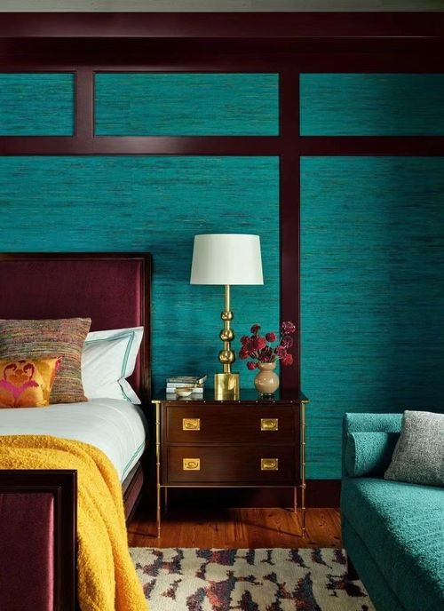 Phòng ngủ chính kết hợp hài hòa giữa màu sắc táo bạo với bầu không khí thư thái đến bất ngờ. Giấy dán tường Élitis bằng lụa màu xanh ngọc làm nền cho các chi tiết gỗ được sơn màu Pelt của Farrow & Ball, một màu tím cà đậm tạo nên điểm nhấn kiến trúc ấn tượng phía sau giường.