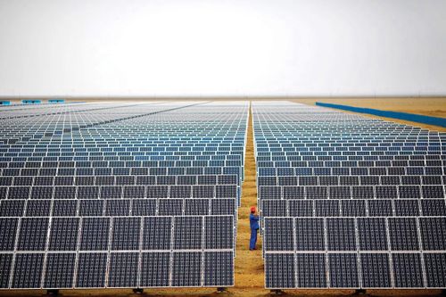 Công nhân đang kiểm tra các tấm pin mặt trời tại một trang trại năng lượng mặt trời ở Đôn Hoàng, cách Lan Châu 950km về phía Tây Bắc, thuộc tỉnh Cam Túc, Trung Quốc